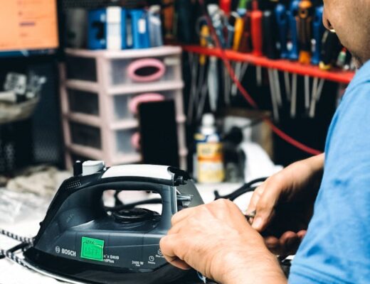 repairman fixing an electric iron in workshop